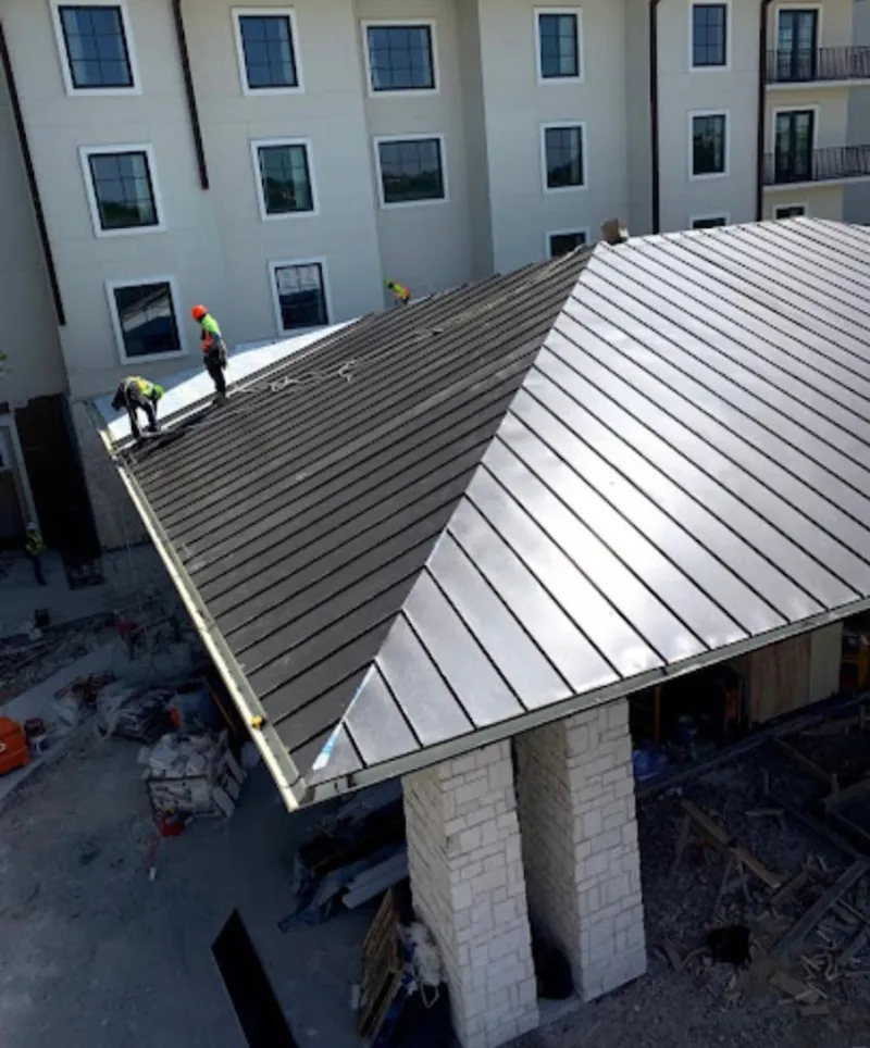 Crew installing standing seam metal roof panels on a commercial project in Minnehaha